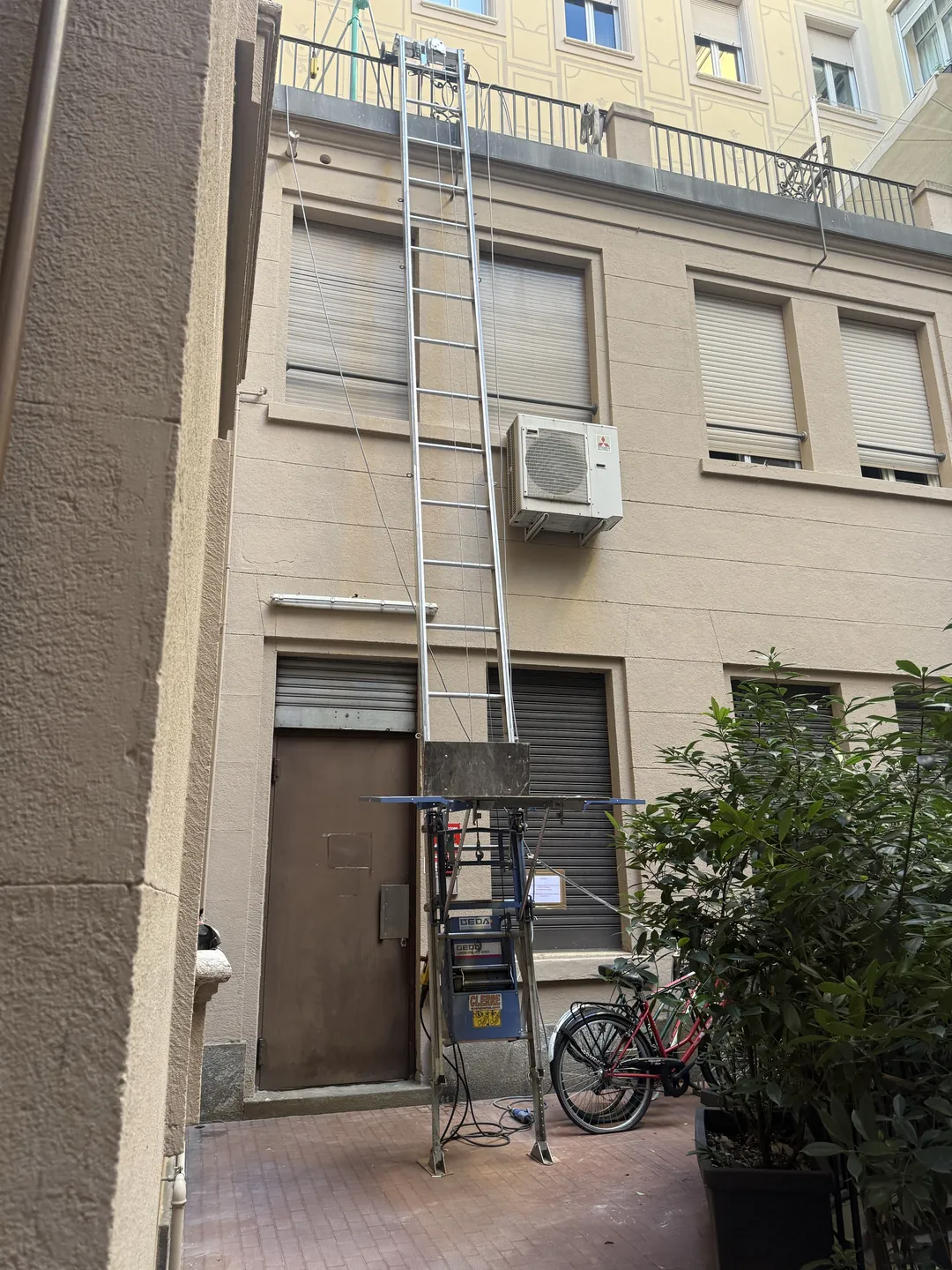 L'autoscala componibile montata nel cortile interno del palazzo di via Roma a Torino, pronta per la salita di arredi e infissi