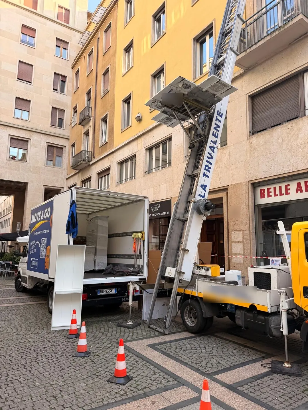 Il furgone Move & Go aperto con i mobili imballati e l'autoscala alzata verso il piano in via Roma a Torino