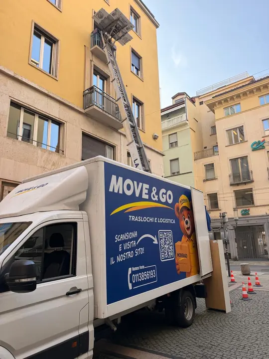 L'autoscala arriva al balcone del palazzo di via Roma mentre il furgone Move & Go aspetta sotto